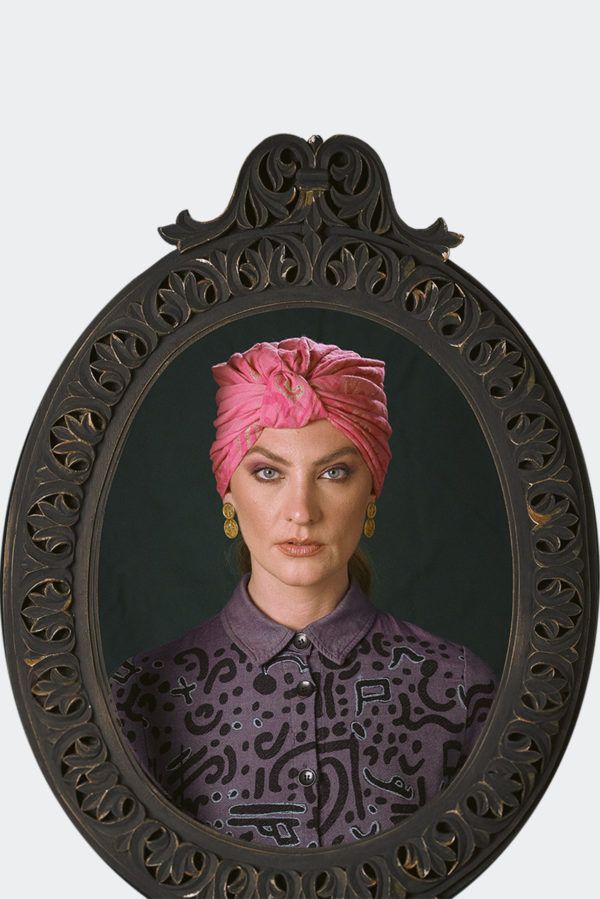 Portrait of a model wearing a pink patterned luxury headpiece, turban